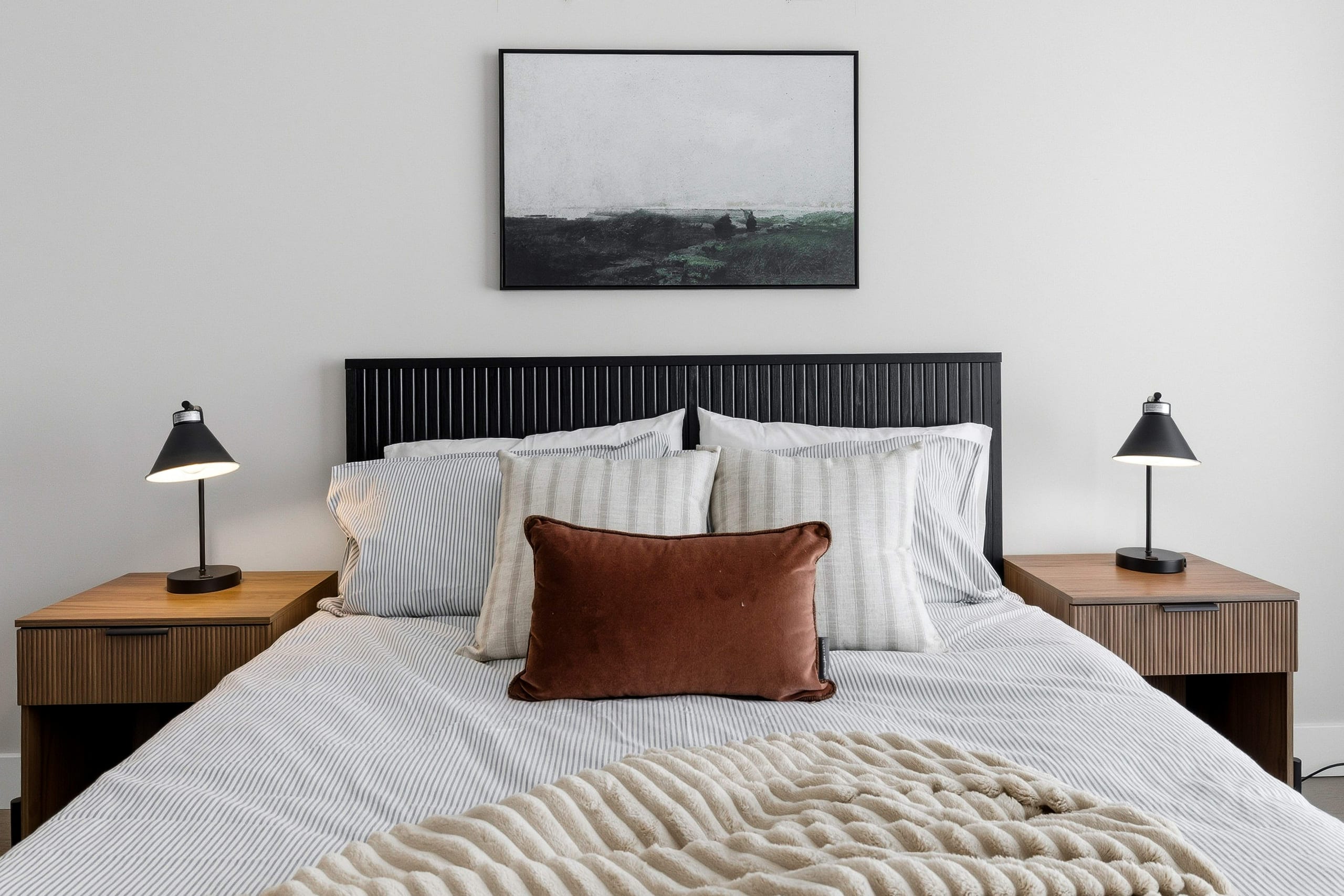 Bedroom with framed art and linens